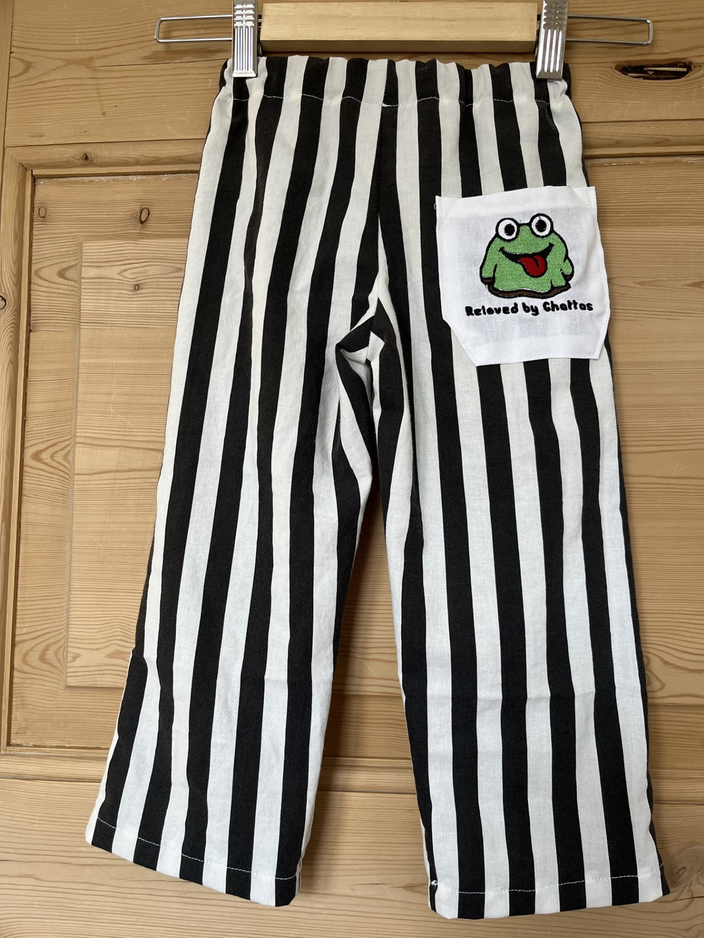 Stribede bukser med broderet frø  – str. 98